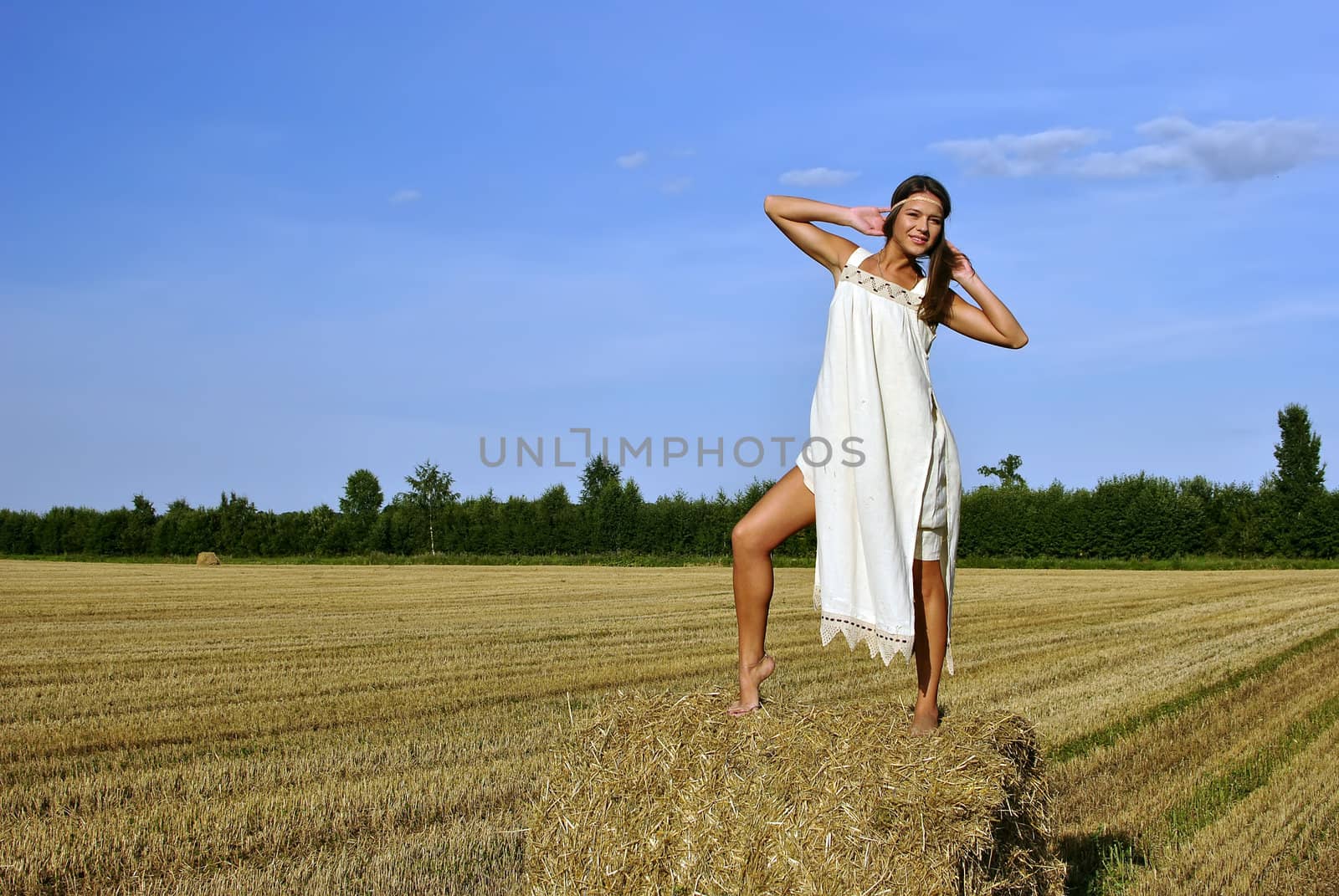 girl in a rural clothing standing on the haystack. space for text