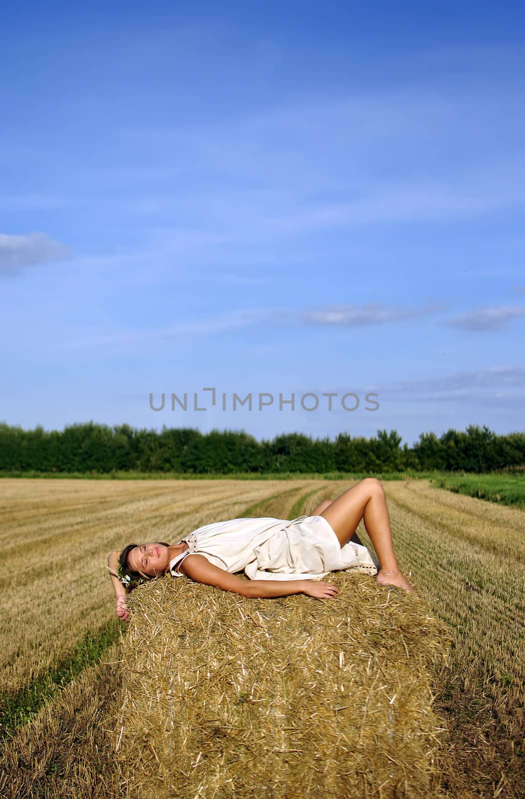 girl in a rural clothing lying on the haystack. space for text