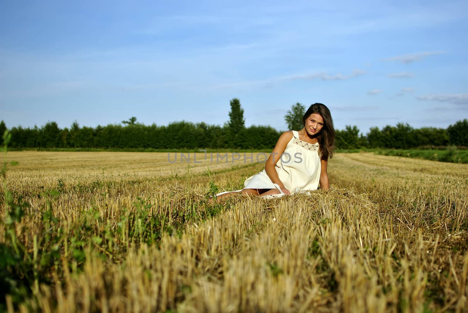 nice girl in national dress, sitting on a field in rural areas, space for text