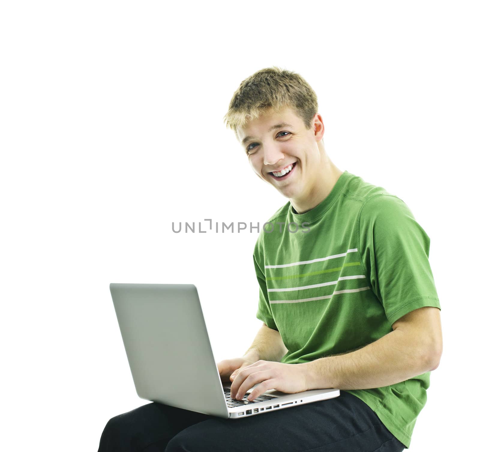 Smiling young man sitting with laptop computer isolated on white background