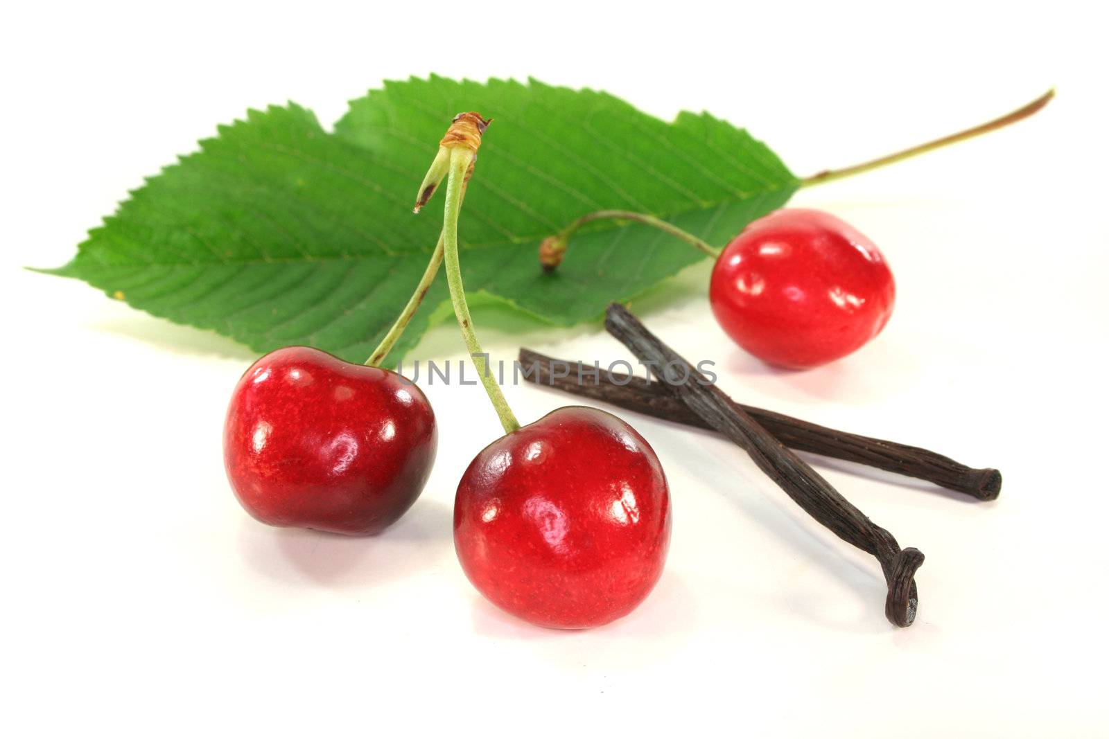 fresh cherries with vanilla on white background