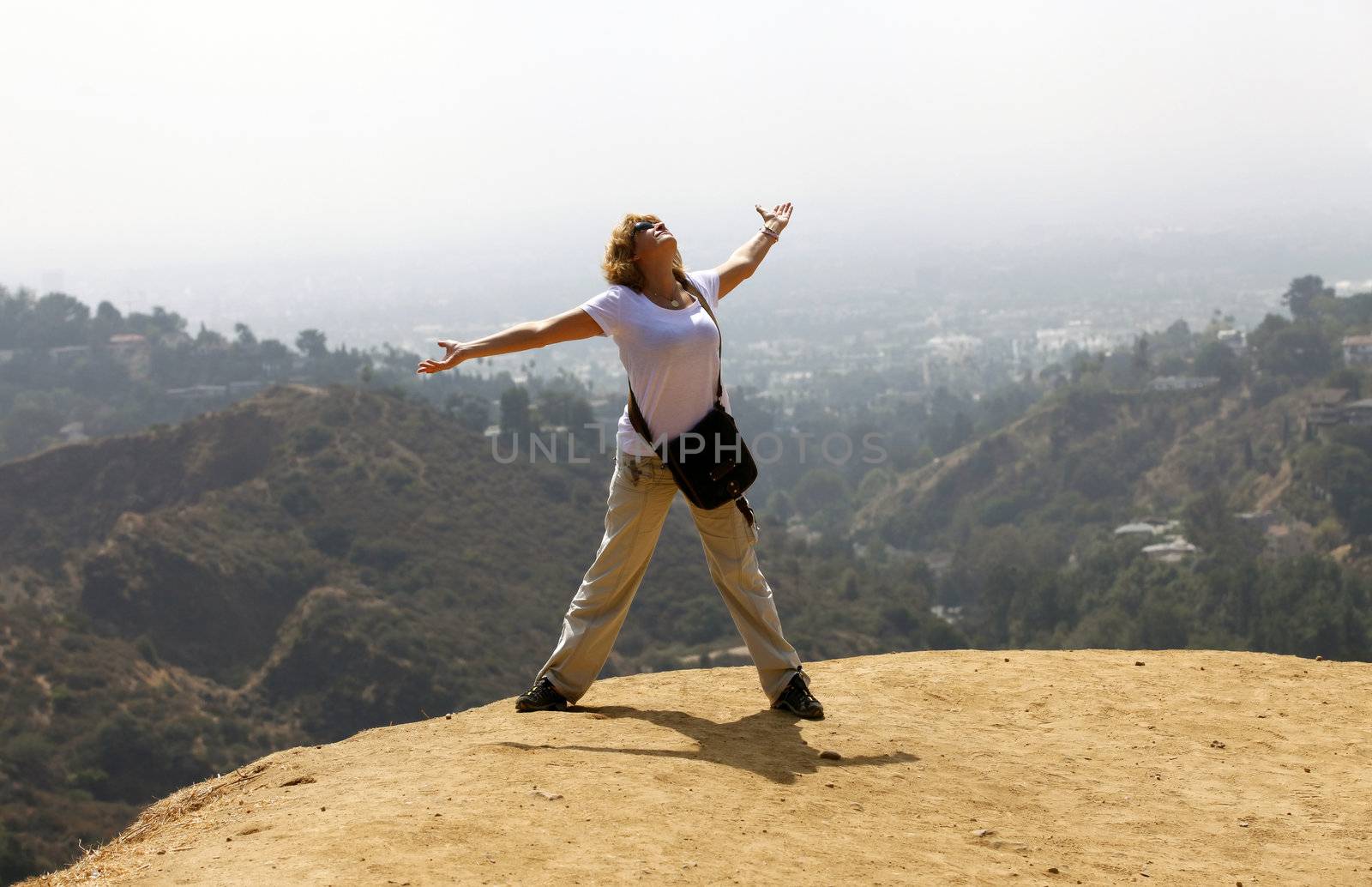 The woman - tourist on the Hollywood hill on background Los Angeles