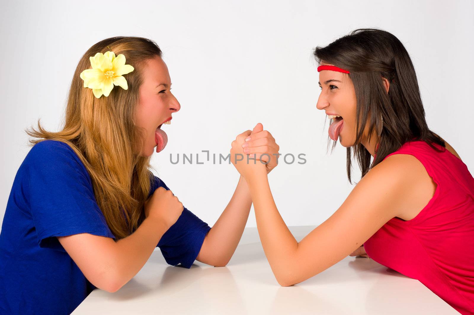 Blond and brunette girl at a crazy arm wrestling contest