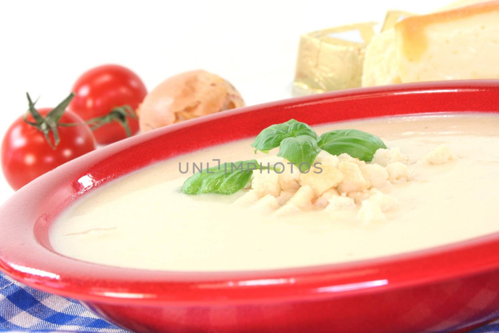 Cheese cream soup with tomato, Croutons and basil on a white background