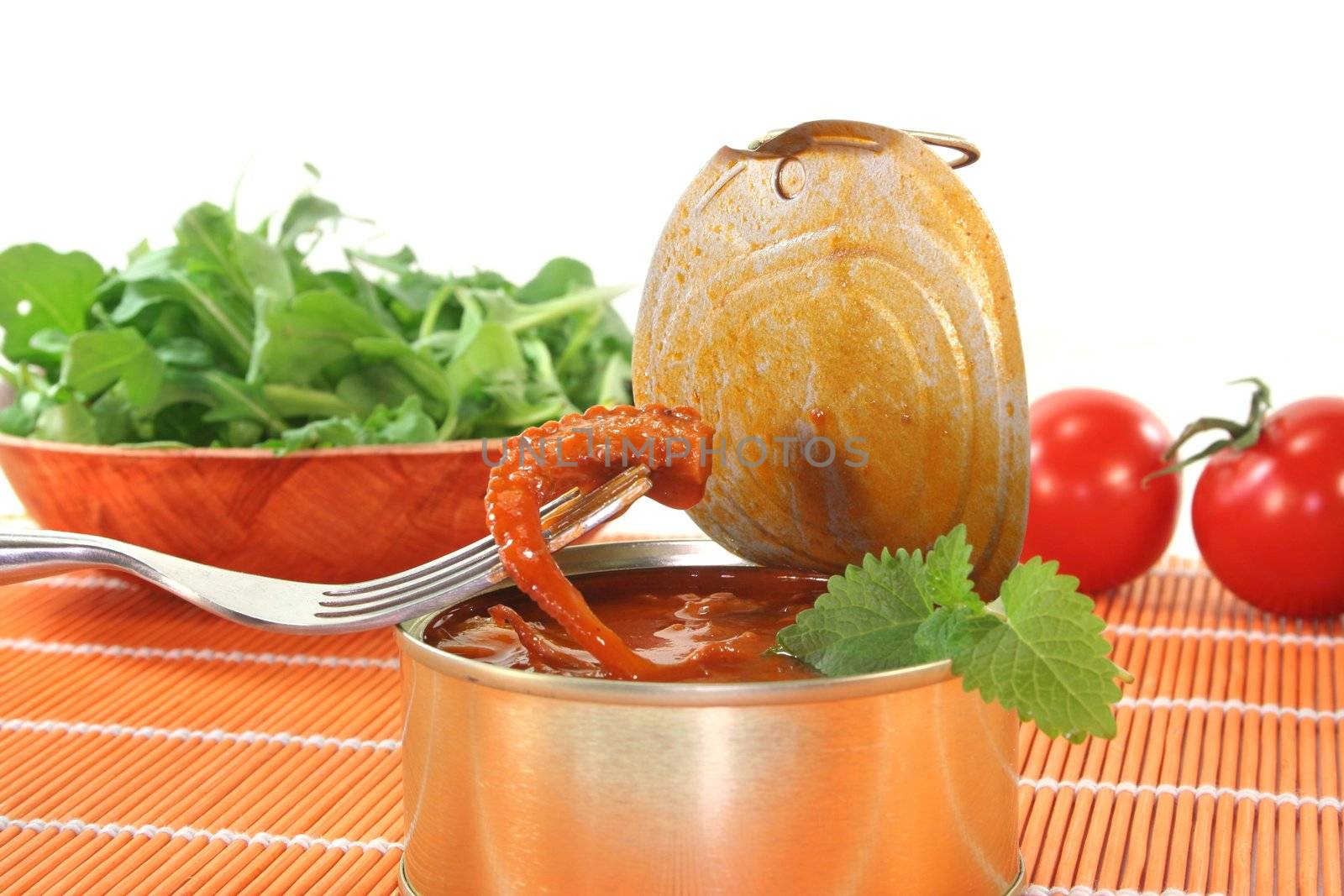 Musky octopus salad on a fork on white background