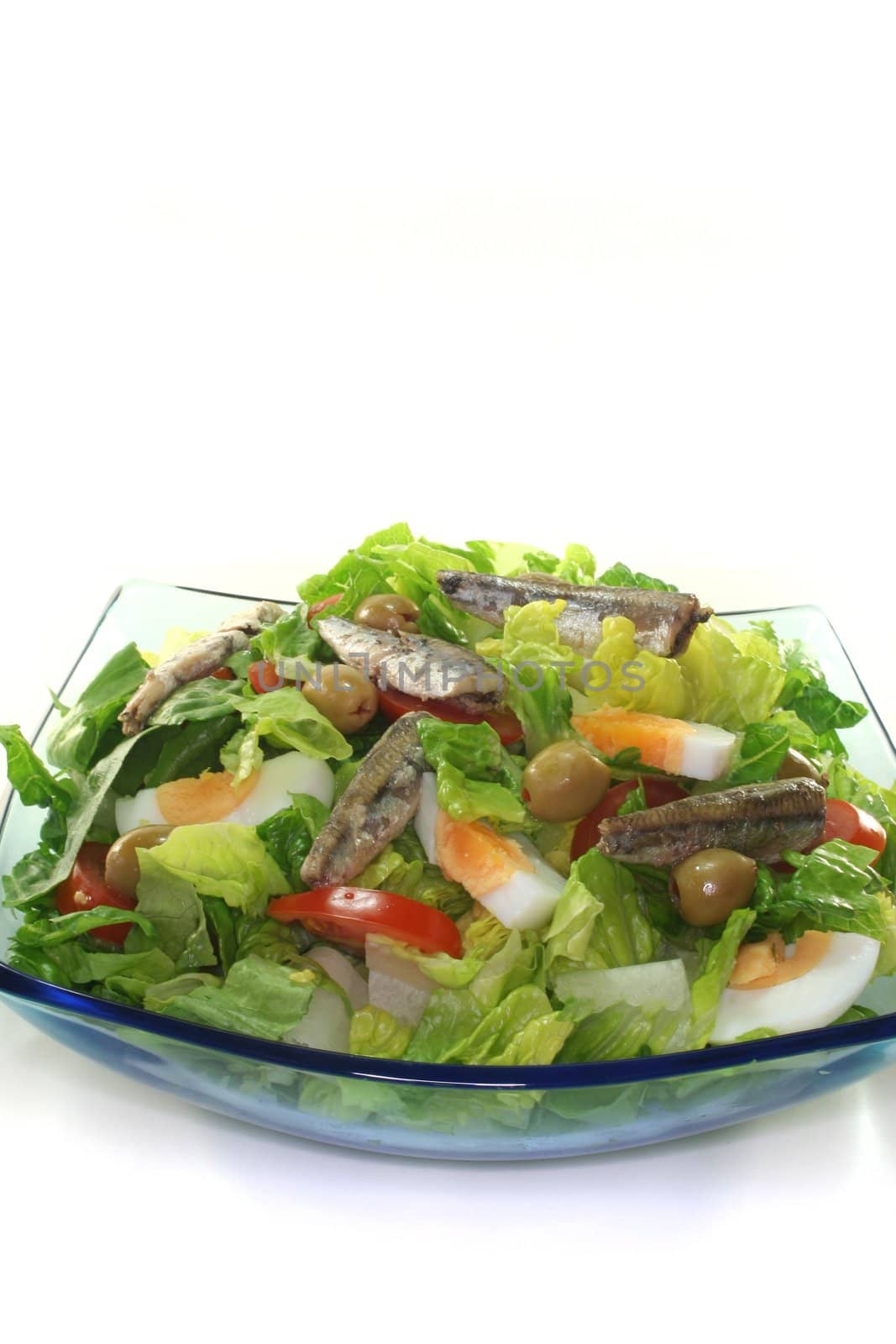 Chef salad with anchovies, egg, tomatoes, olives and salad leaves