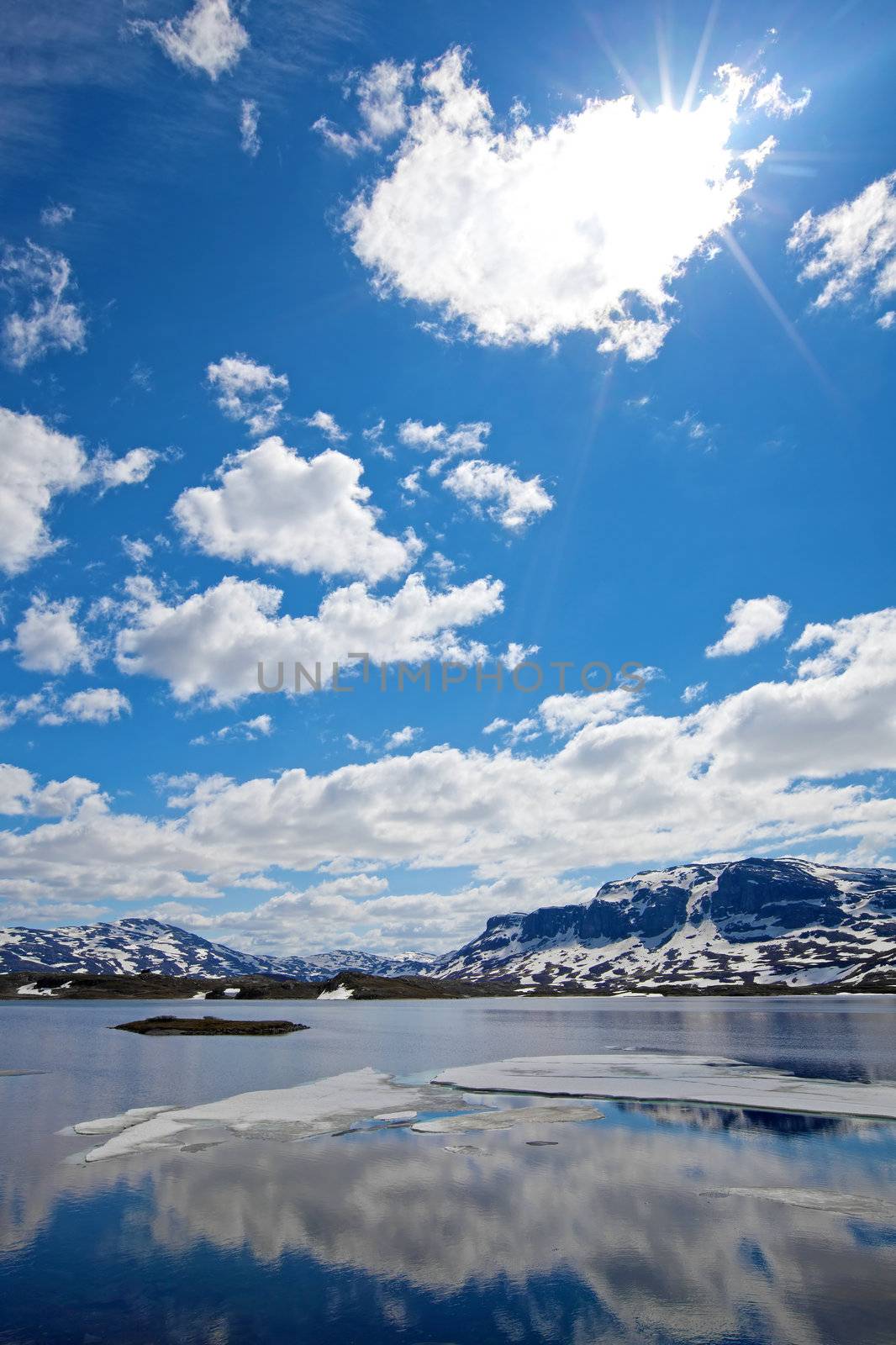 Snowcapped mountains reflecting in the water at Haukeli, Norway