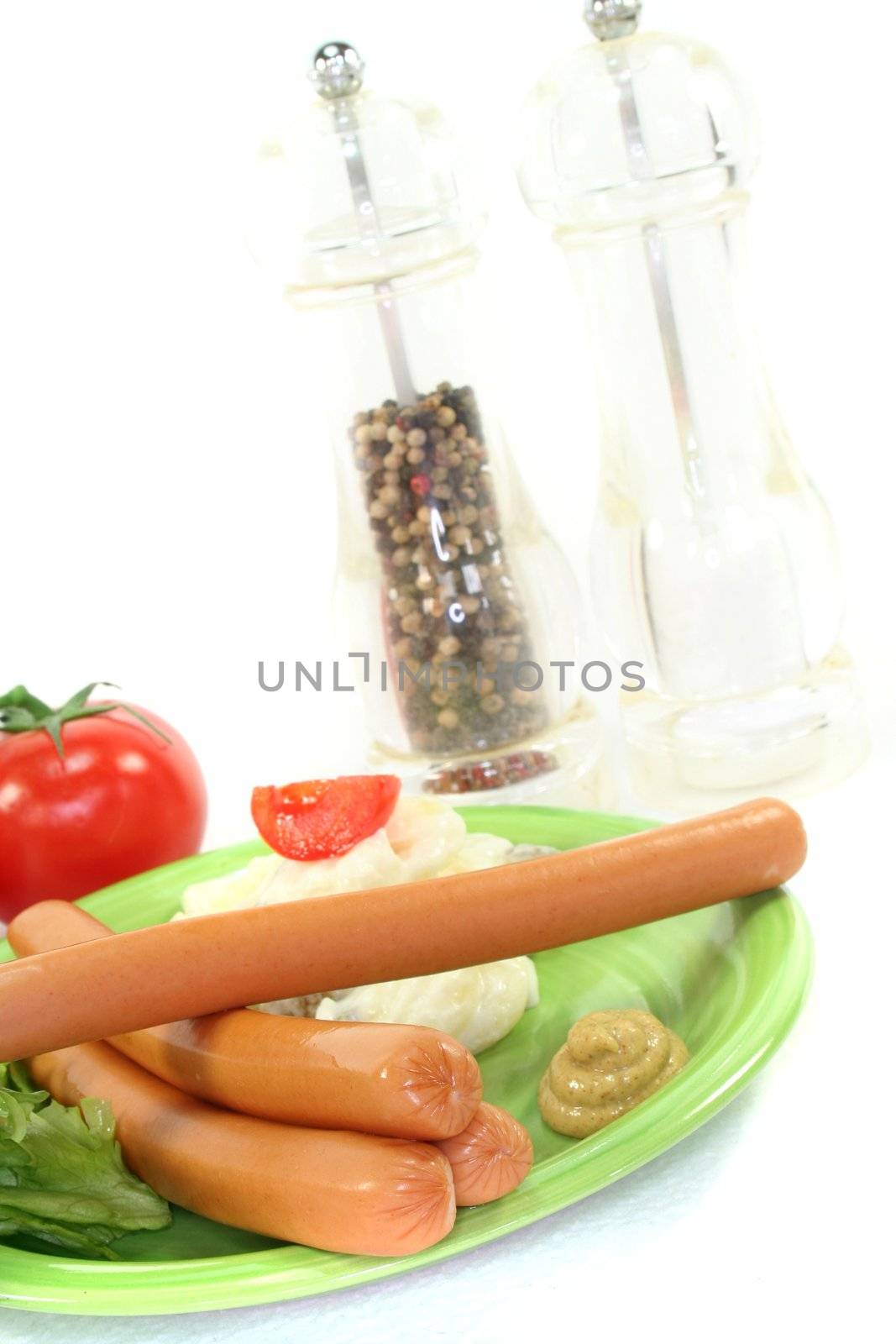 Wiener Sausage with potato salad and lettuce on a white background