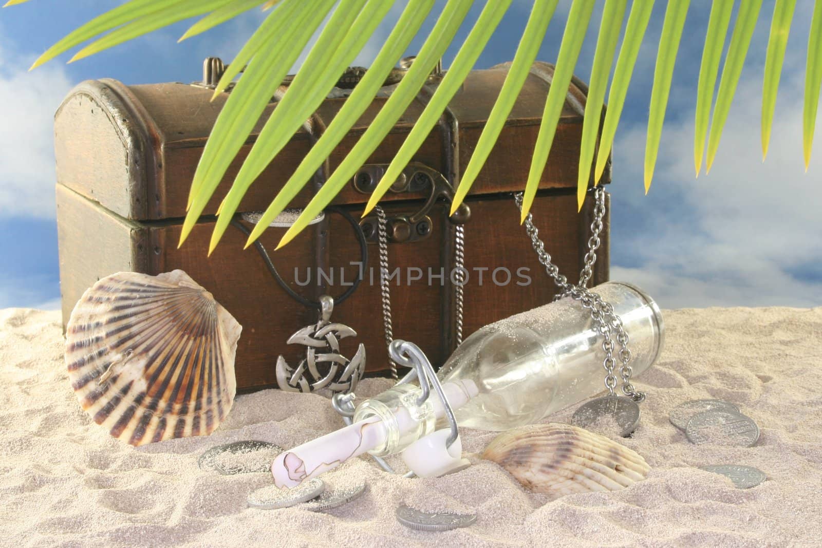 Bottle post with old coins, old chest in the sand and shell