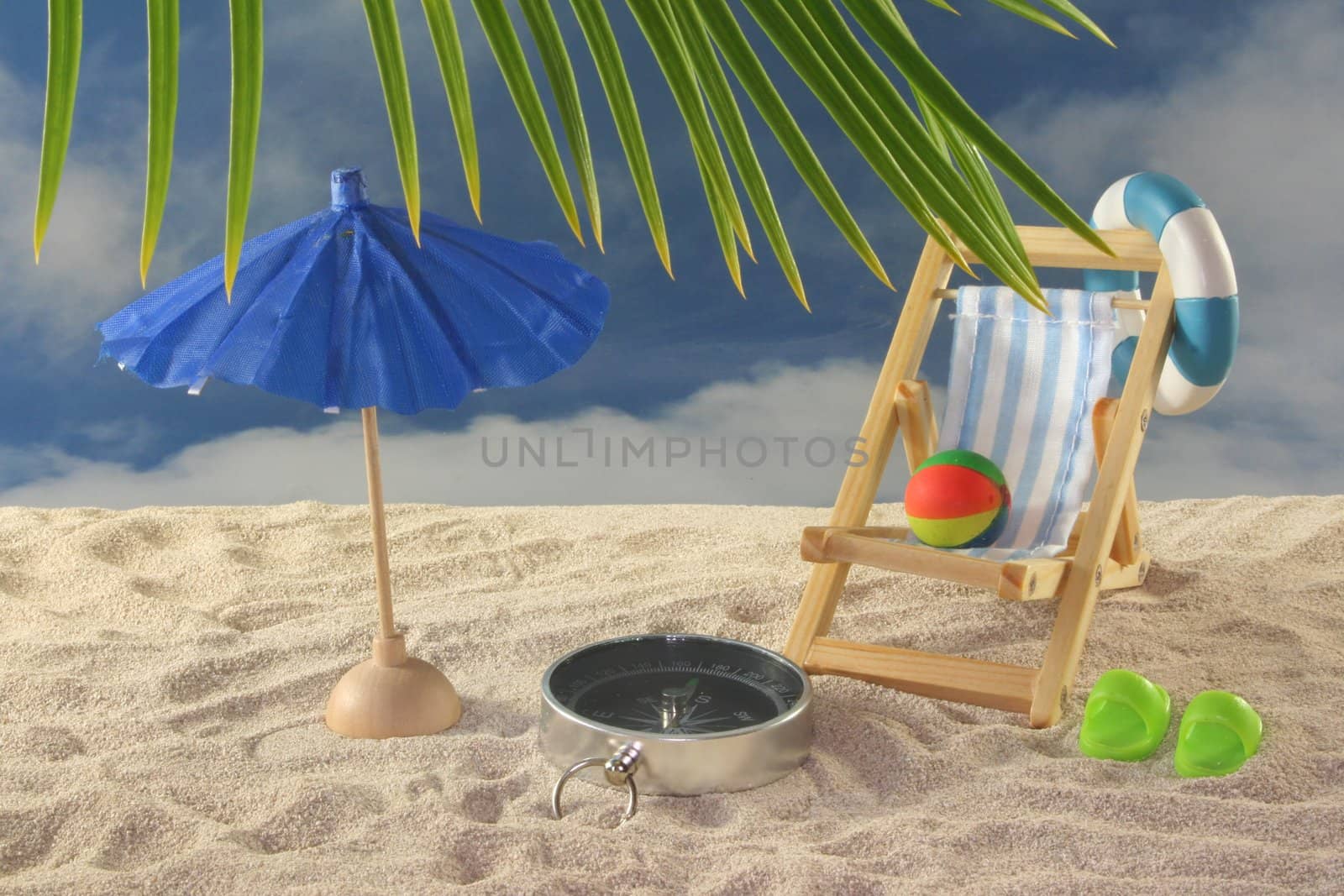 Compass with deck chair and umbrella on a sandy beach