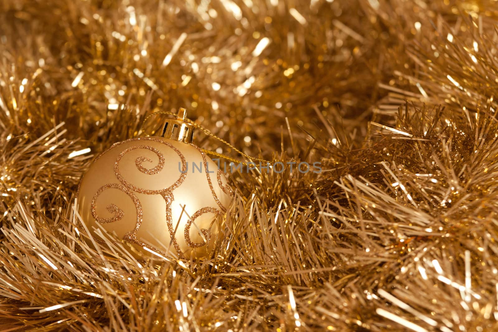 Golden Christmas decorations: bauble and tinsel.