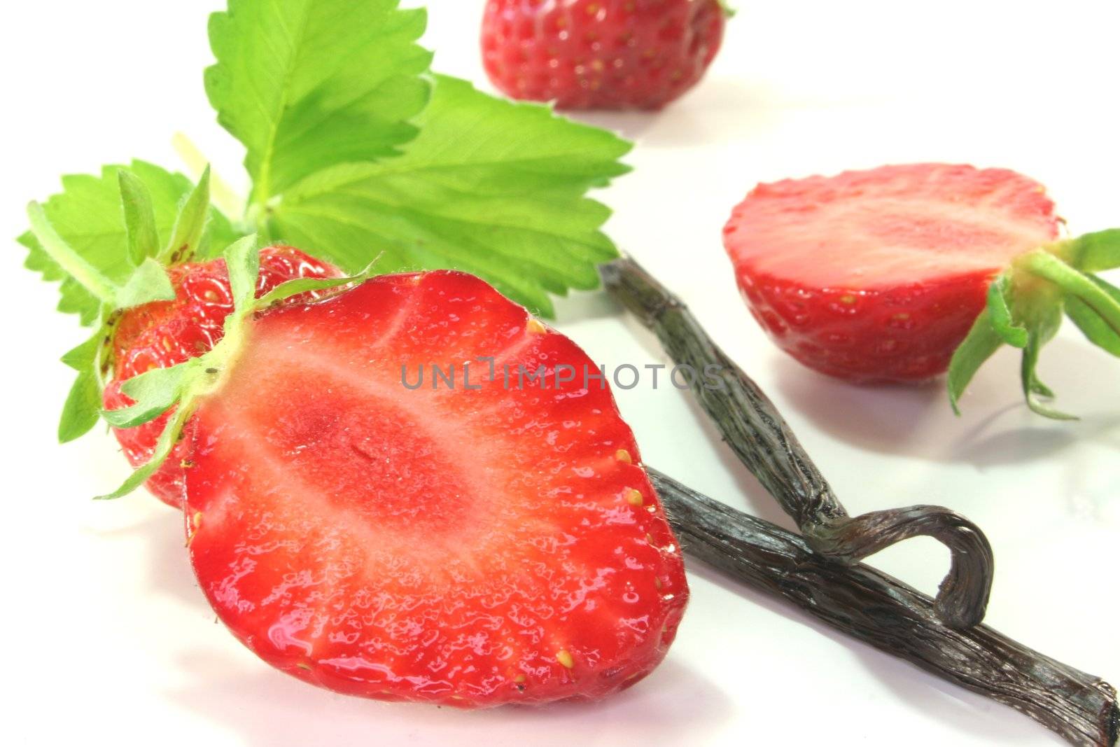 fresh half strawberries with vanilla on a white background