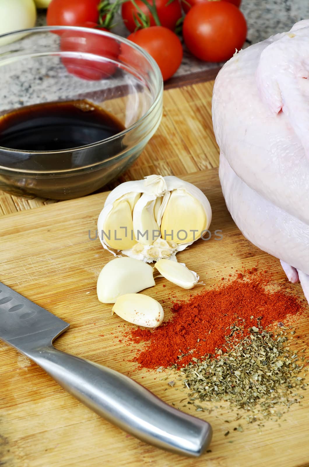 chicken, spices, knife, garlic and soy sauce on kitchen board