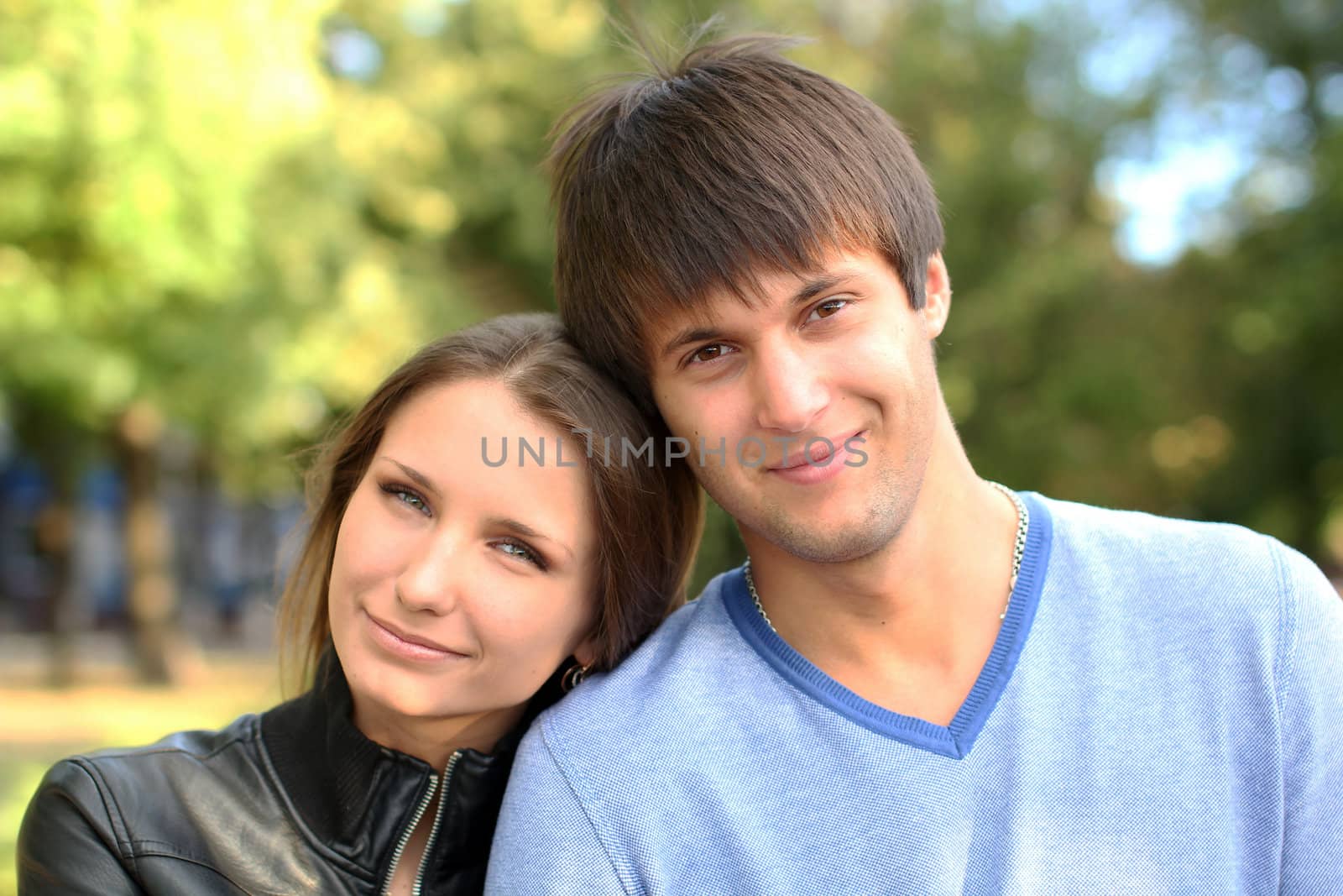 Young couple on a green background of the park by Legioner476