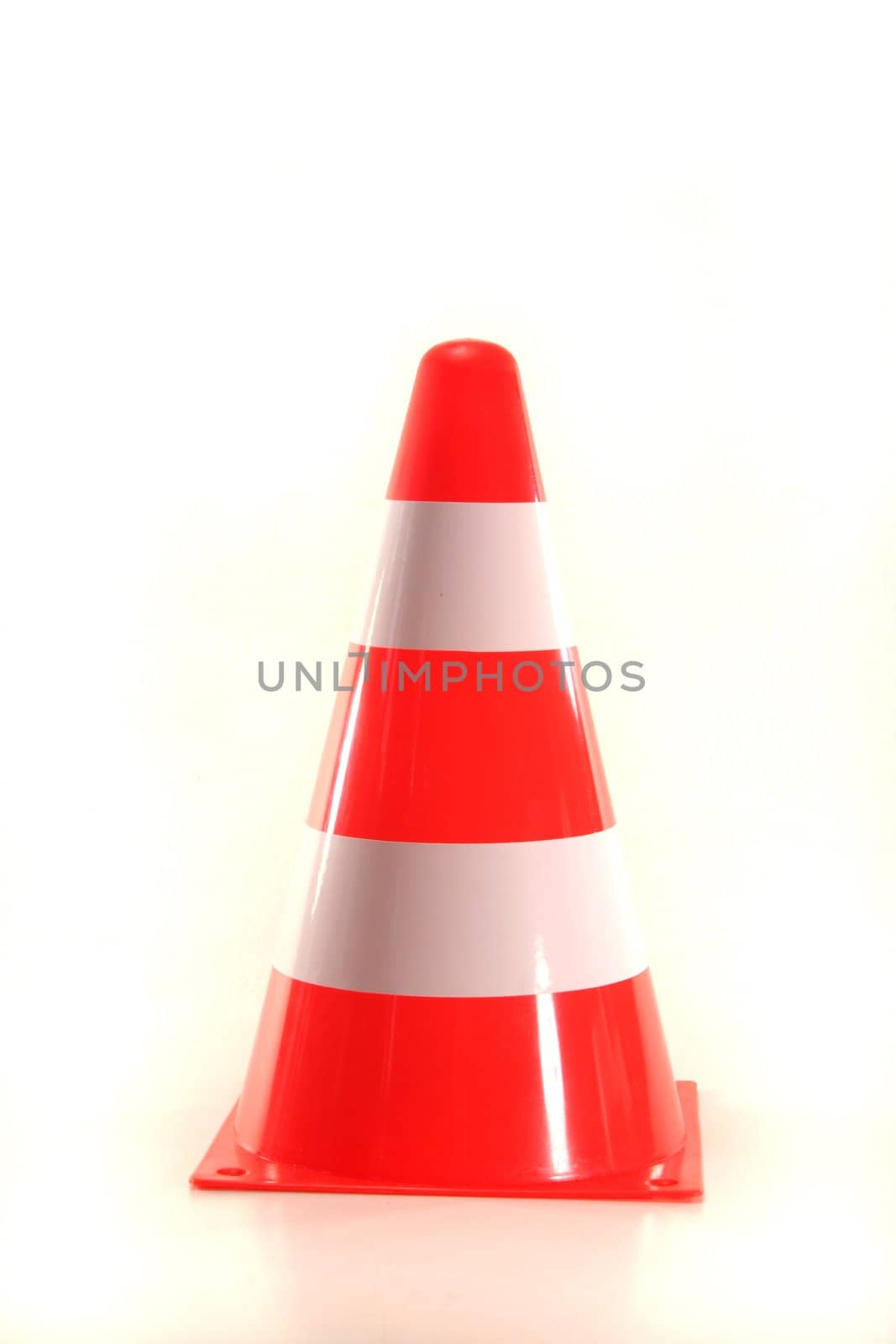 red and white construction pylon before a white background