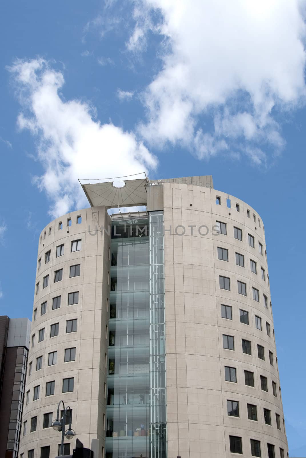 Unusual Round Office Block with External Elevator under a blue sky