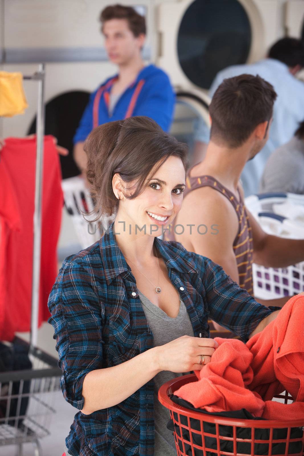 Beautiful Caucasian lady smiles in the laundromat 