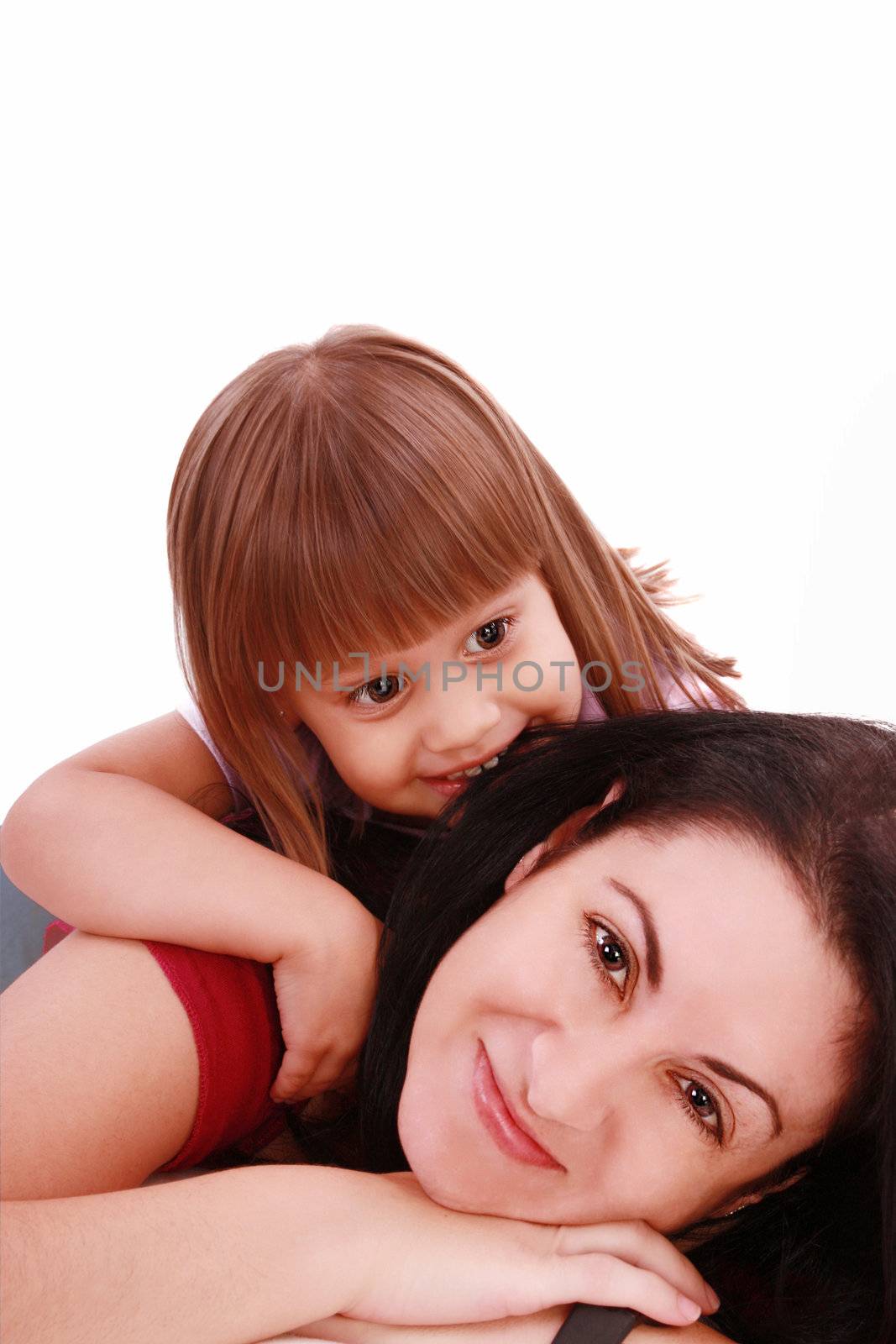 A portrait of a mother and her baby girl lying on the floor and smiling over white background