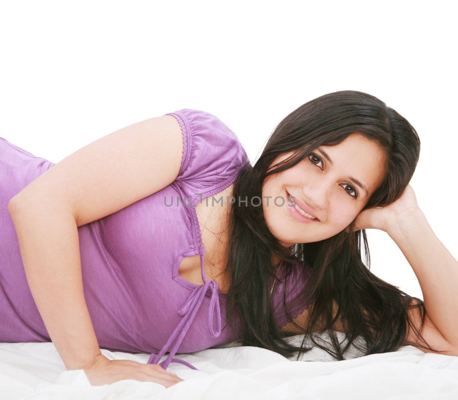 Smiling young woman laying on bed