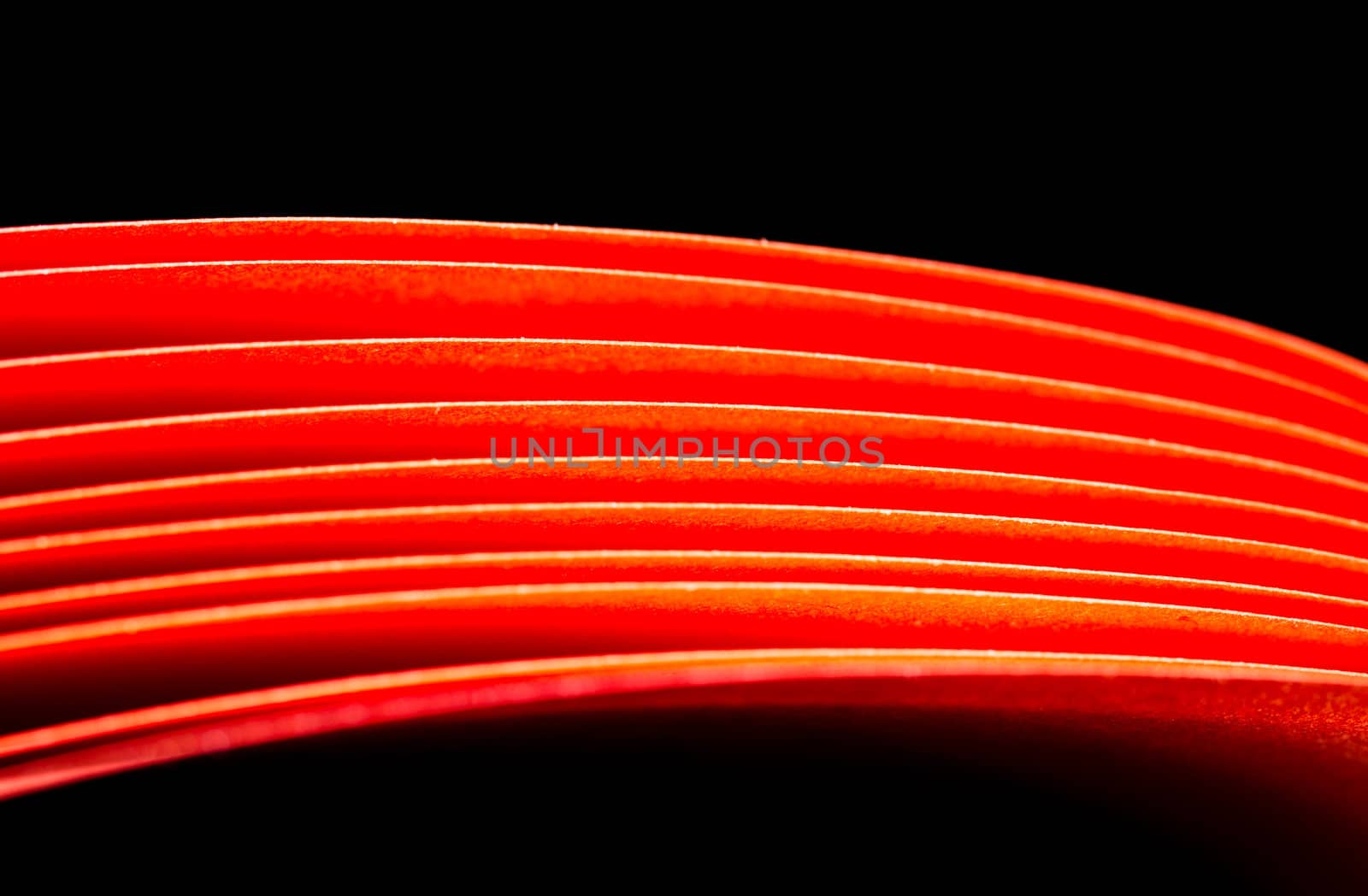 Red A4 paper illuminated with LED lights with black background in landscape orientation