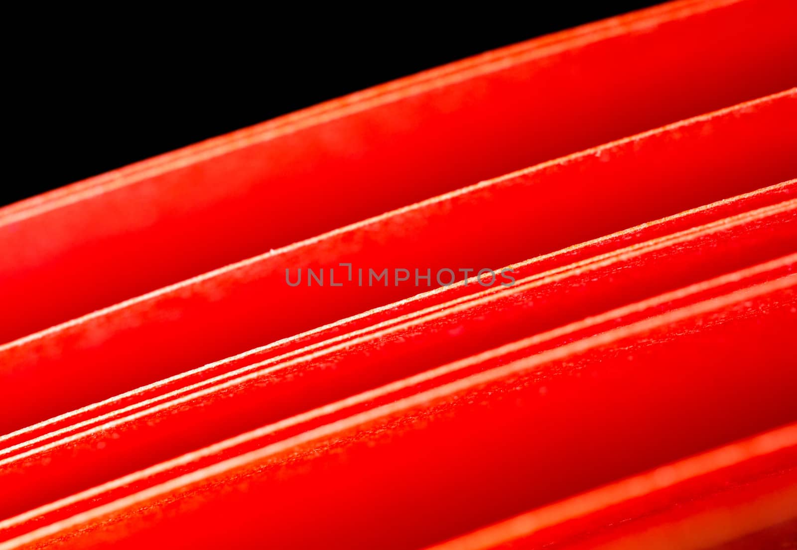 Texture of the red A4 paper illuminated with LED lights in black background