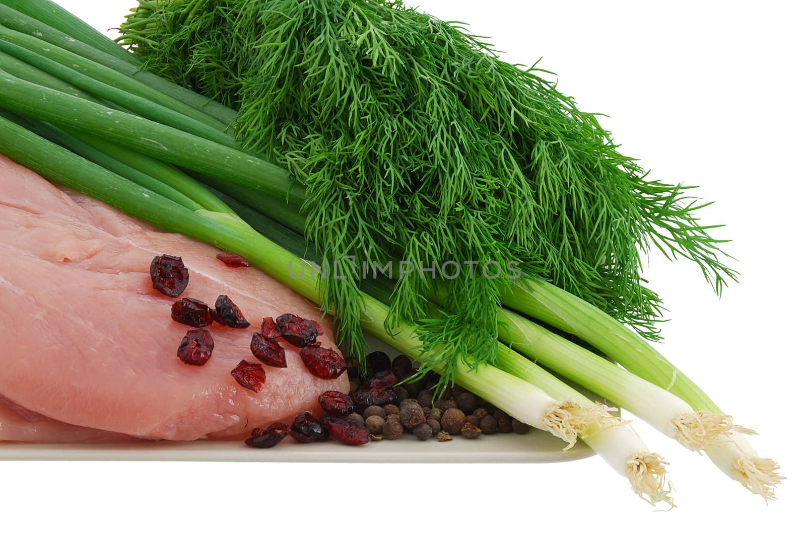 Raw turkey breast with green vegetables and cranberries on plate by vadidak