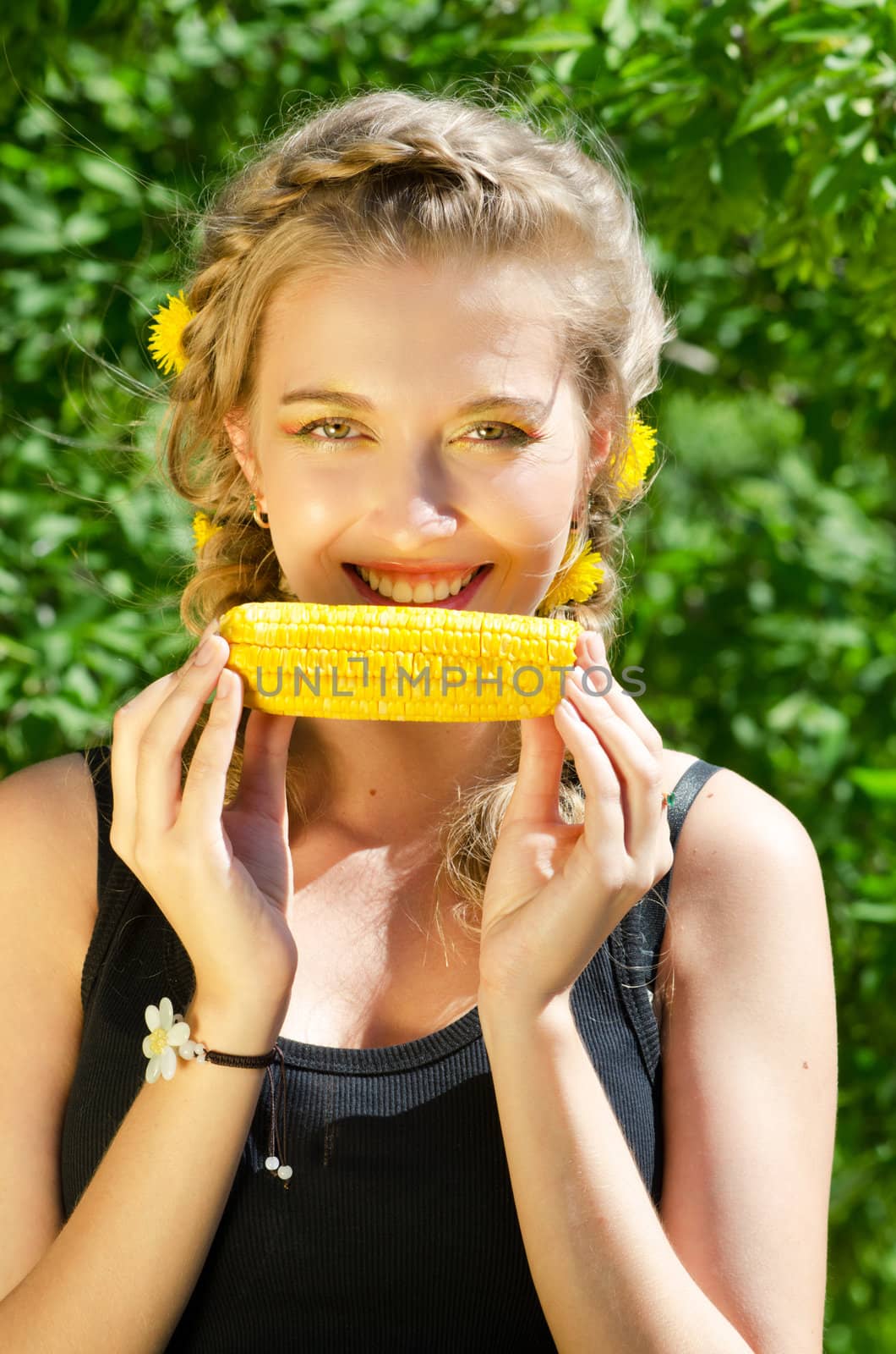 Close-up outdoor portrait of young beauty woman eating corn-cob