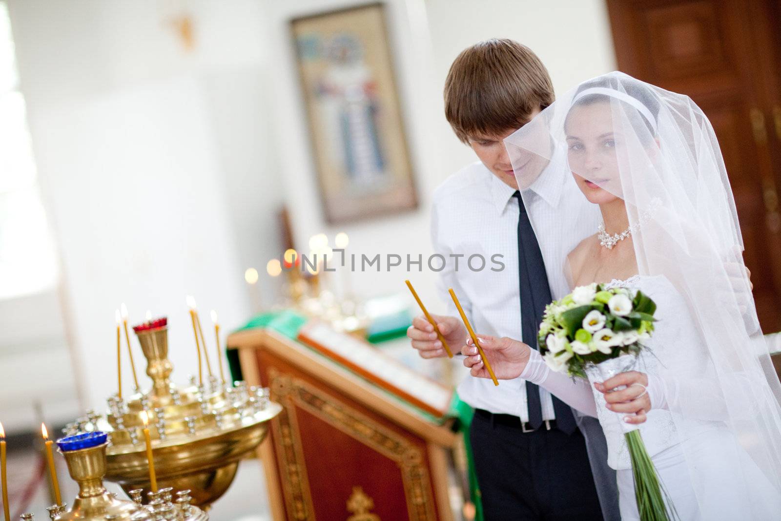 couple lighting candles in a church