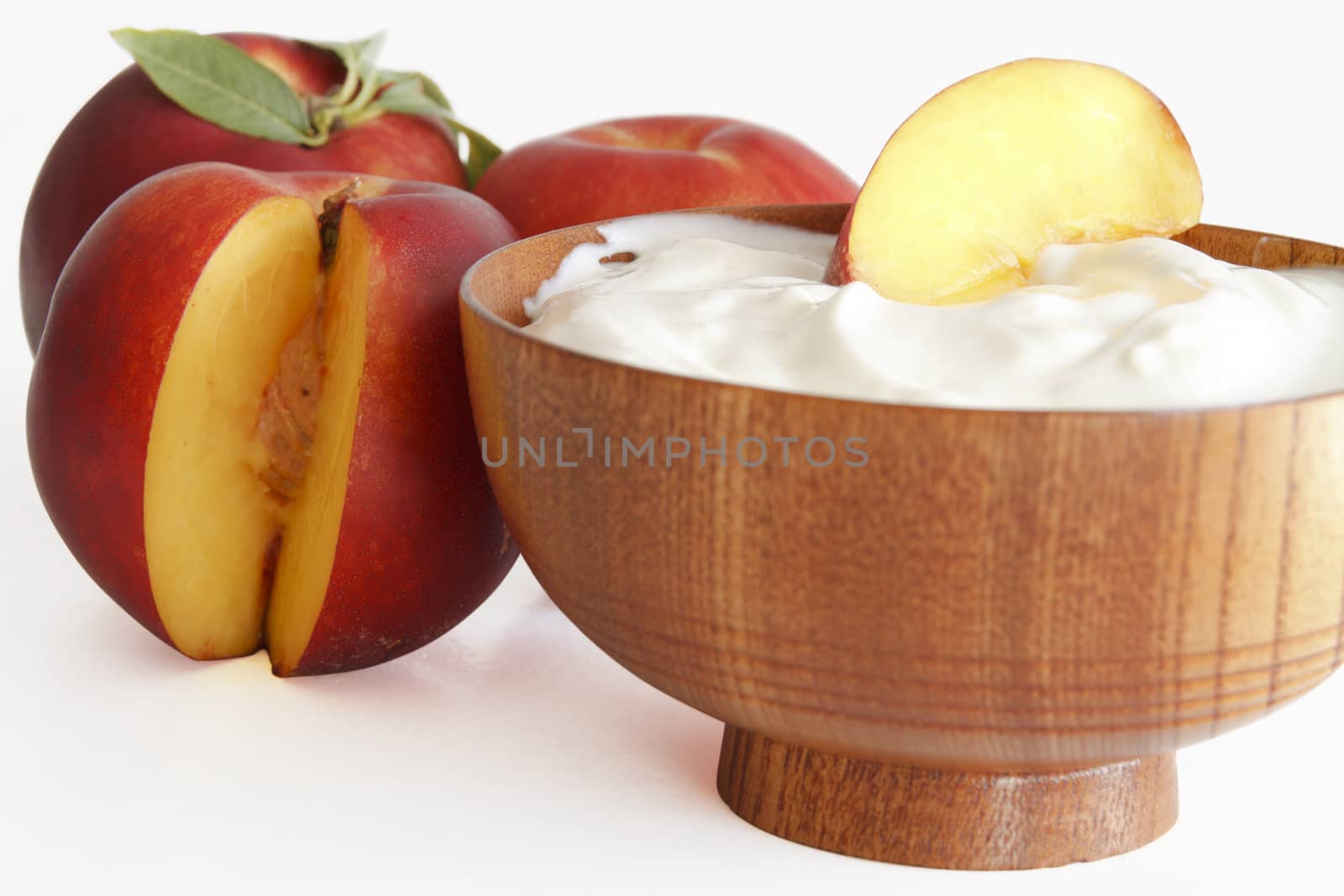 yogurt with peaches in a wooden bowl