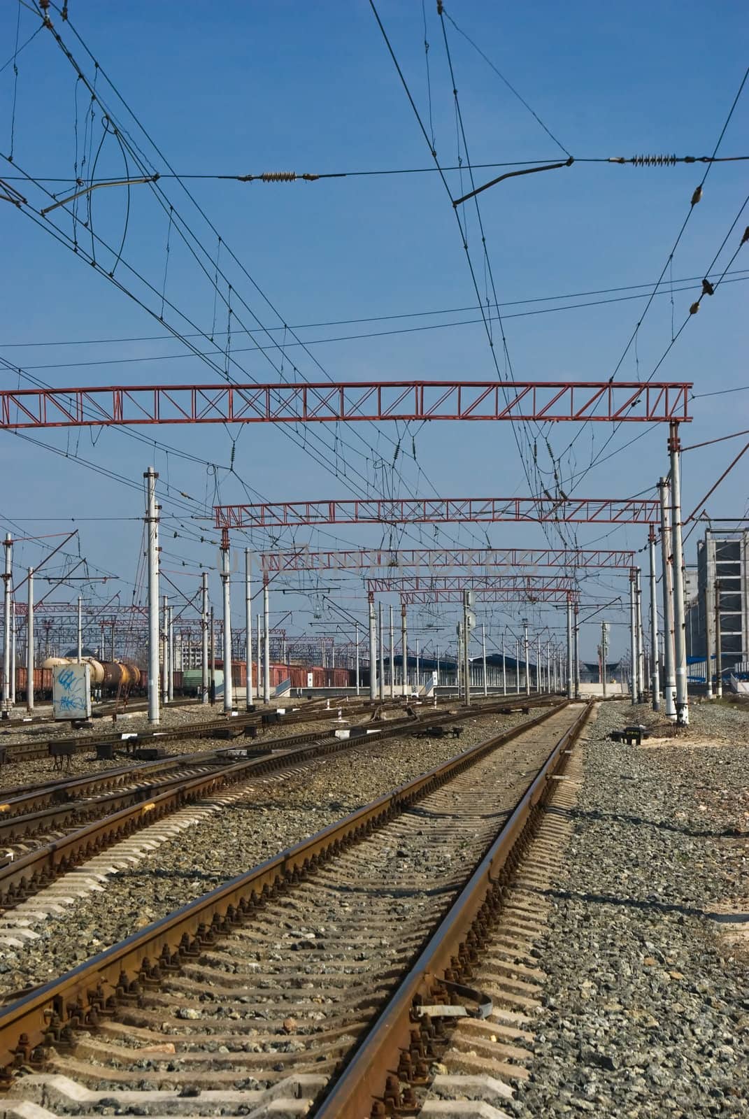 Railway junction. Perspective of crossing rails, traffic lights and train.