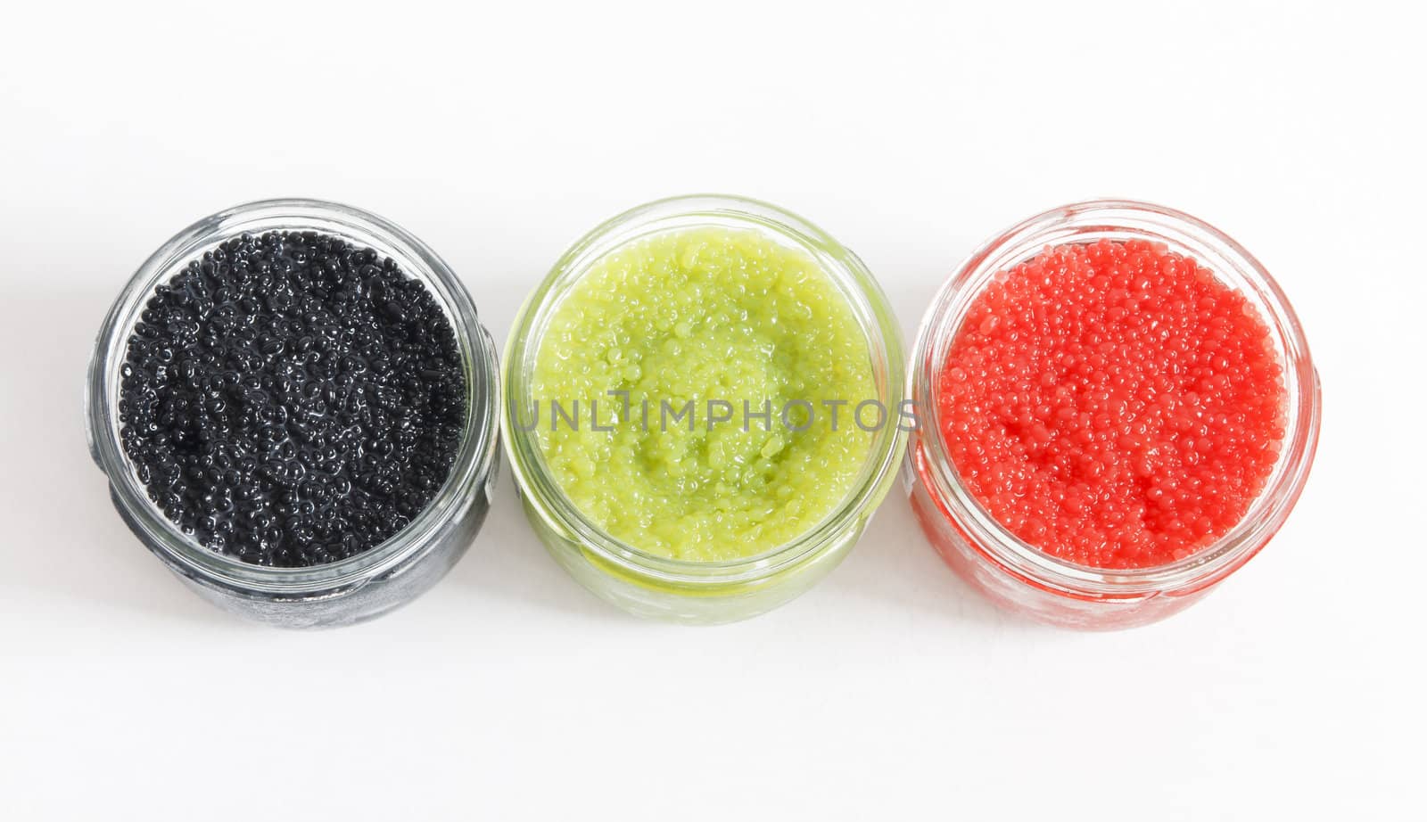 the red, green and black caviar in glass jars on withe background