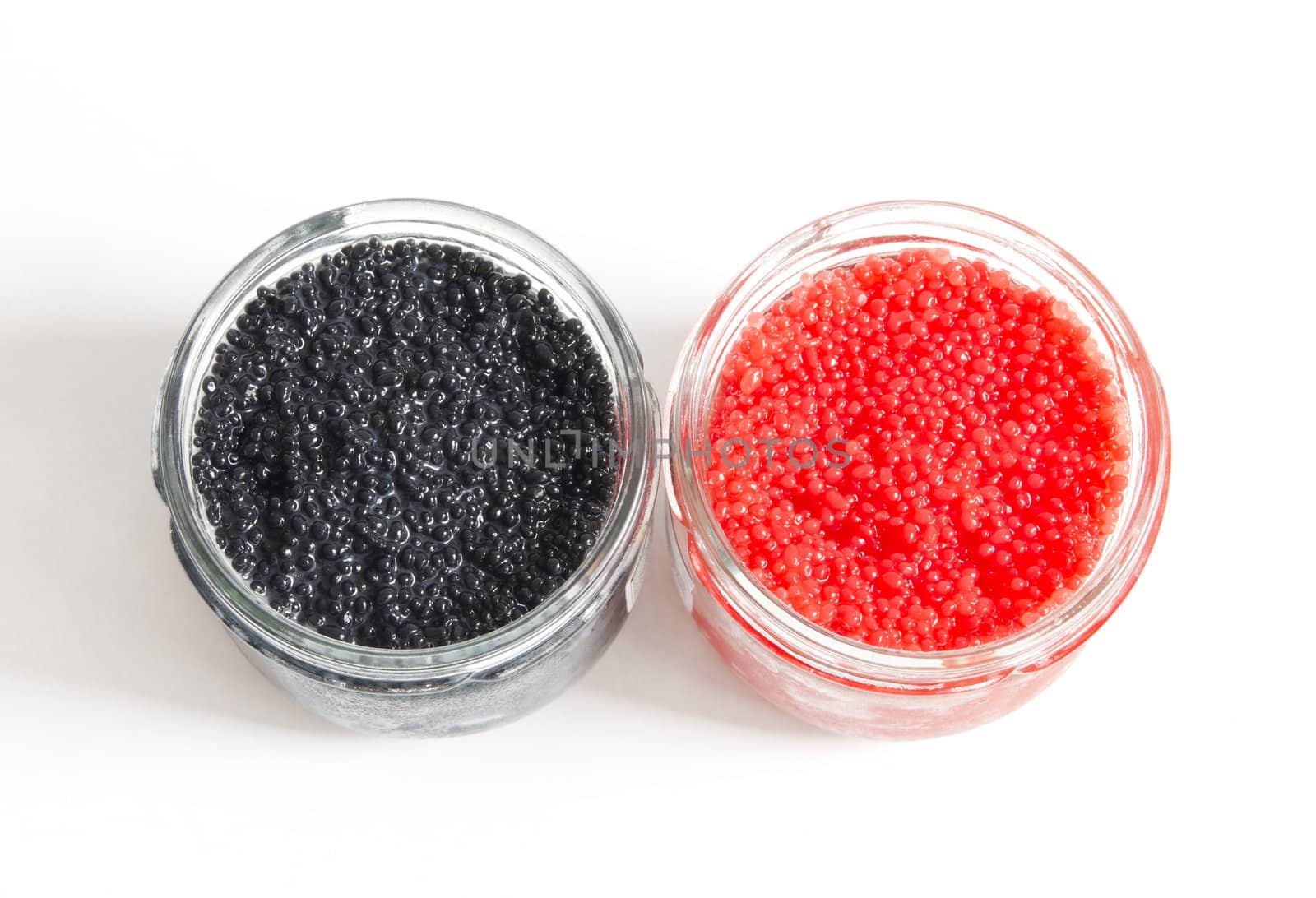 the red and black caviar in glass jars on withe background