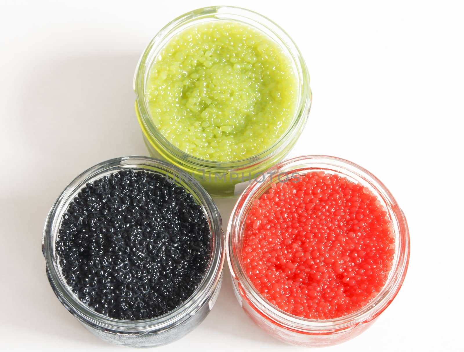 the red, green and black caviar in glass jars on withe background