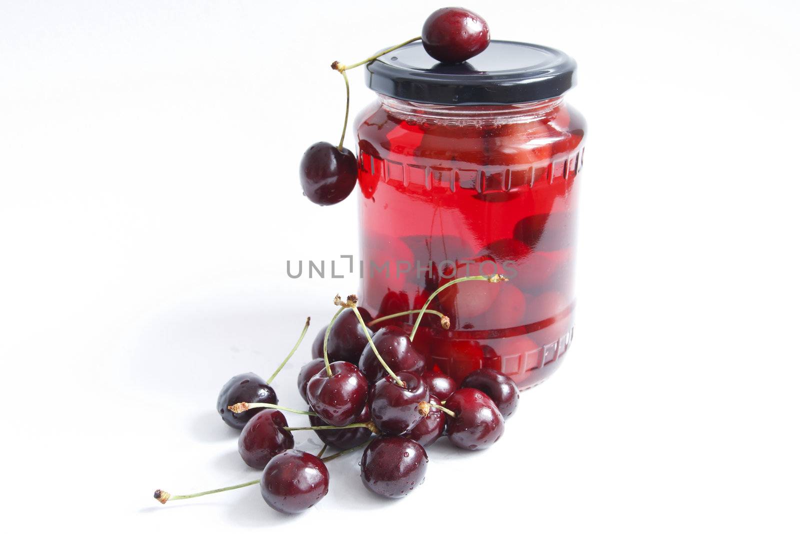 jar with red cherry against the white background