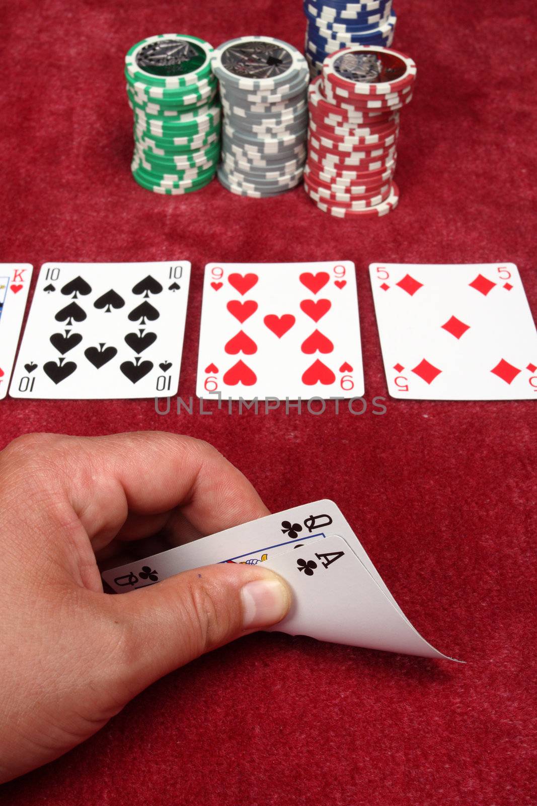 A hand holding two cards in a game of poker