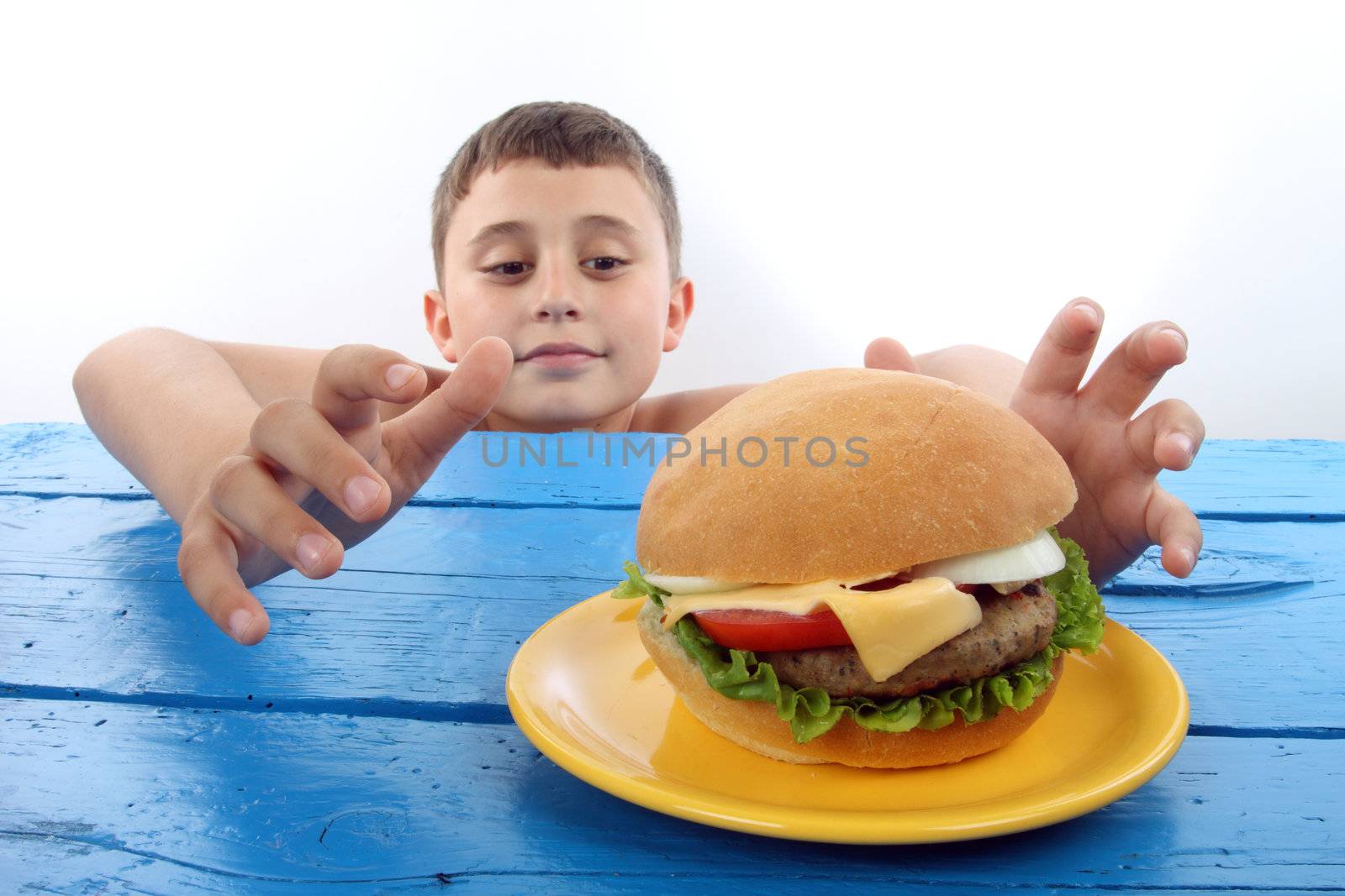 boy grabs a big hamburger close up 