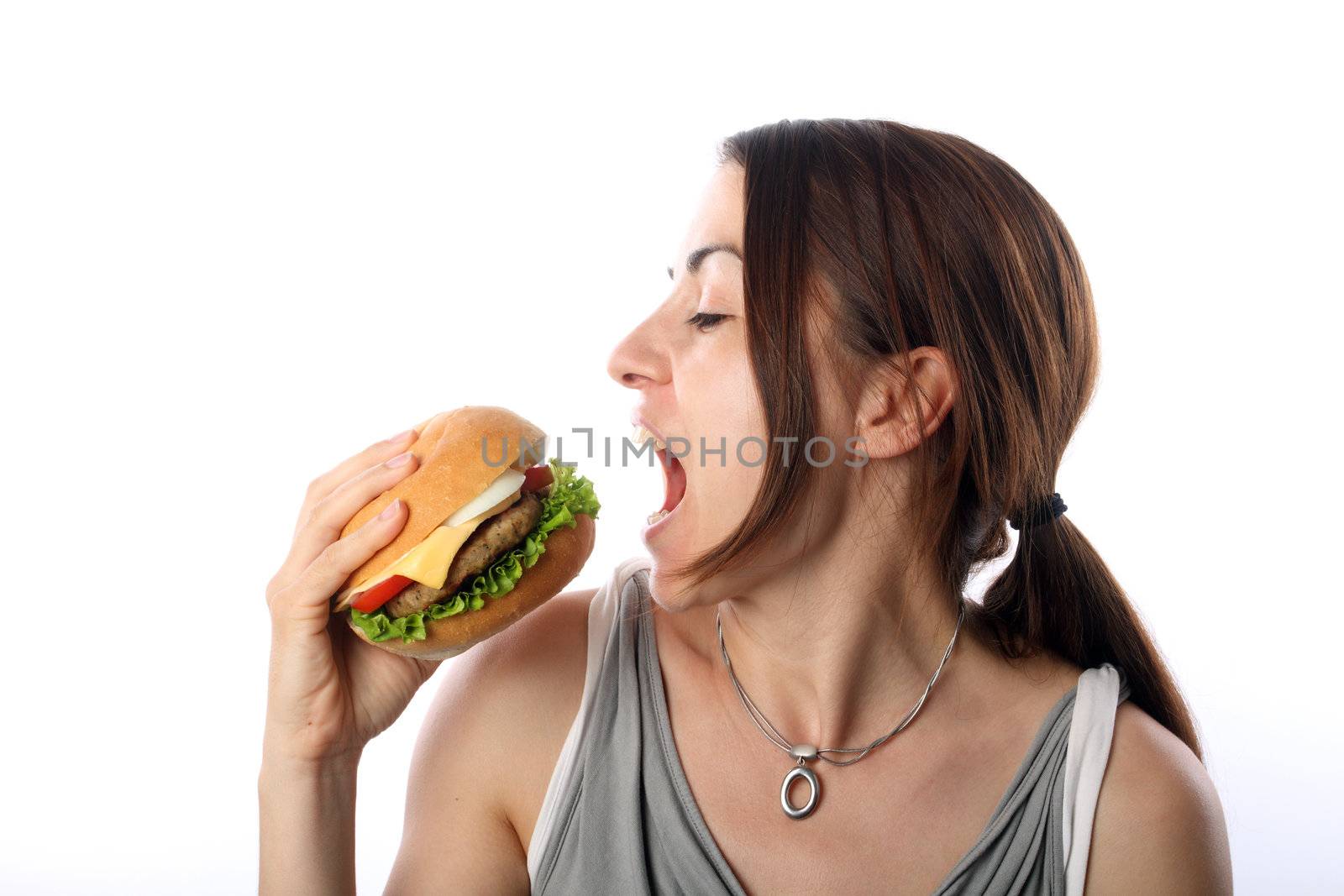 Young woman eating hamburger over white background