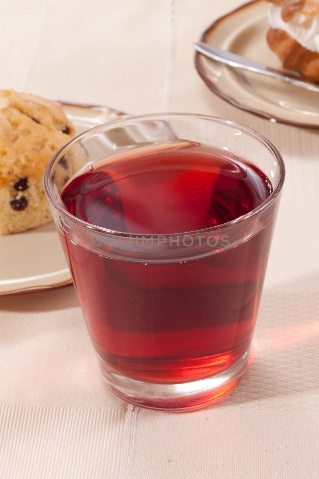 a glass of juice on a table with cookies
