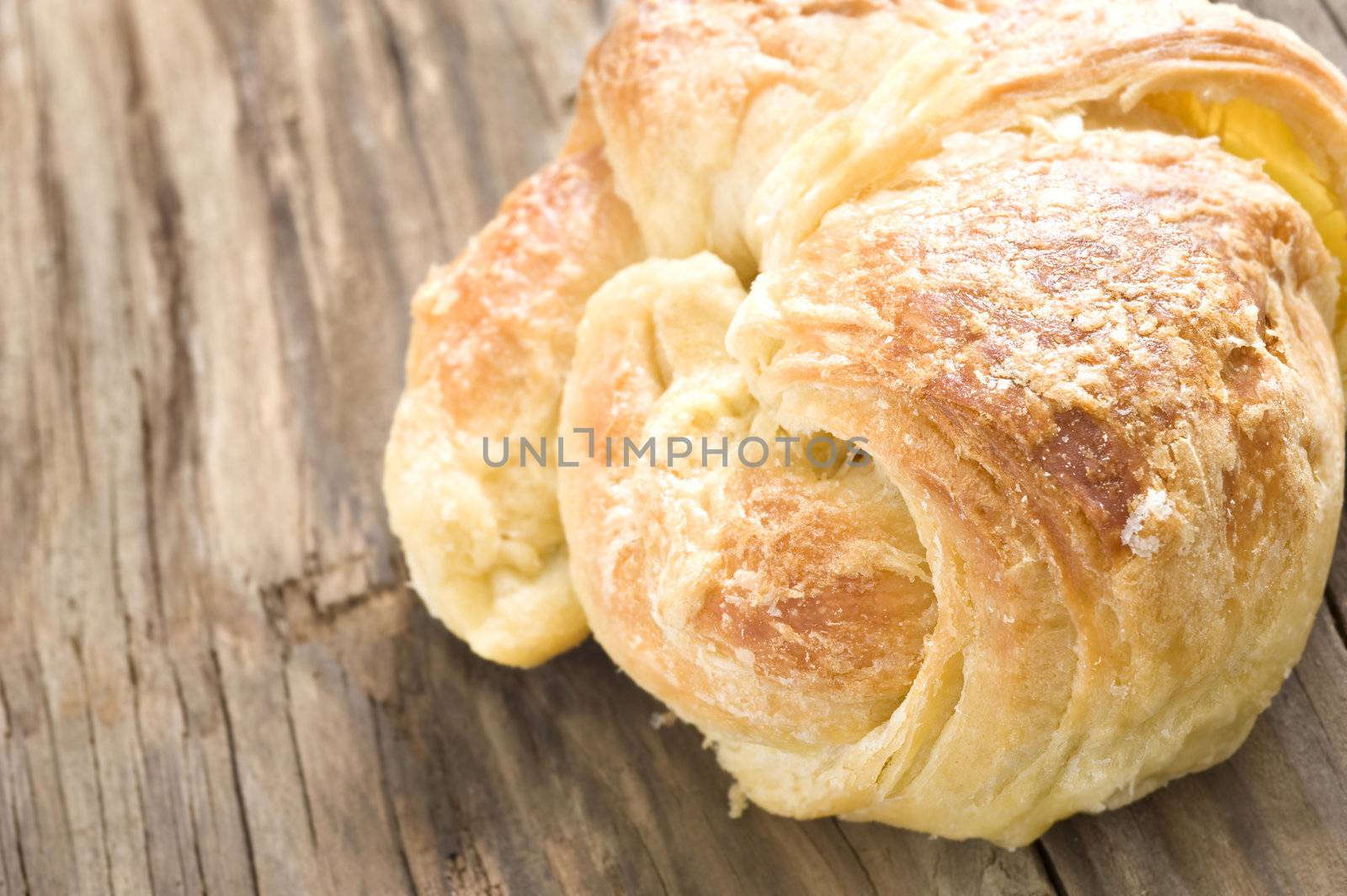 Close up of fresh croissants on a wooden surface by tish1
