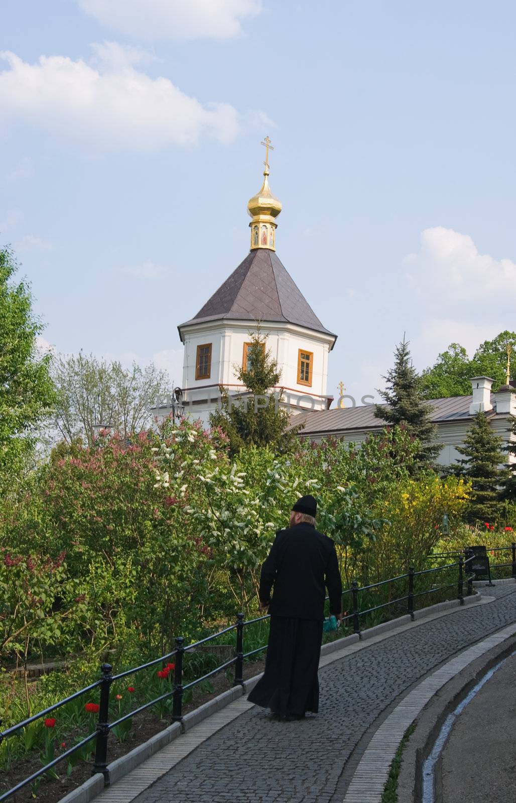 Orthodox priest walking towards  monastery