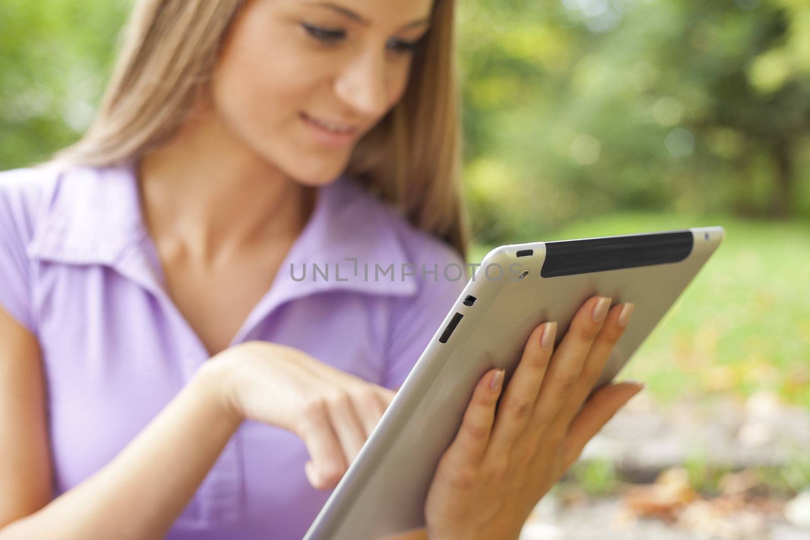 Beautiful Young Woman With Tablet Computer In Park