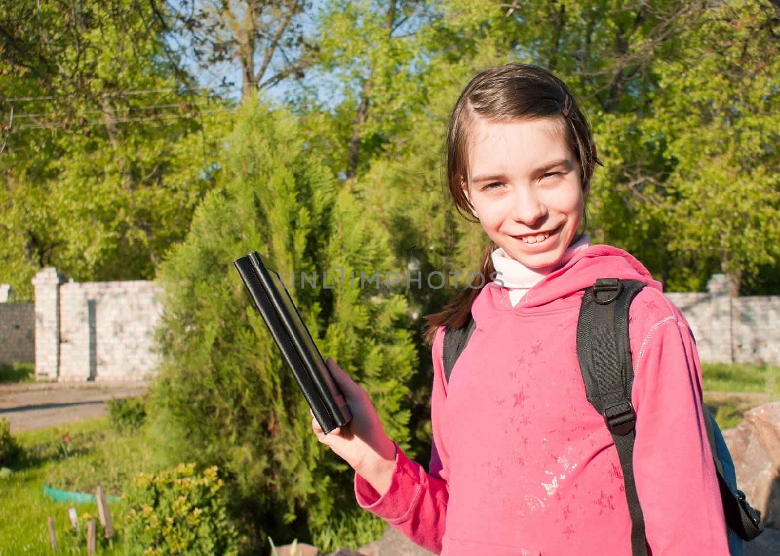 Teen girl with e-book reader outdoors
