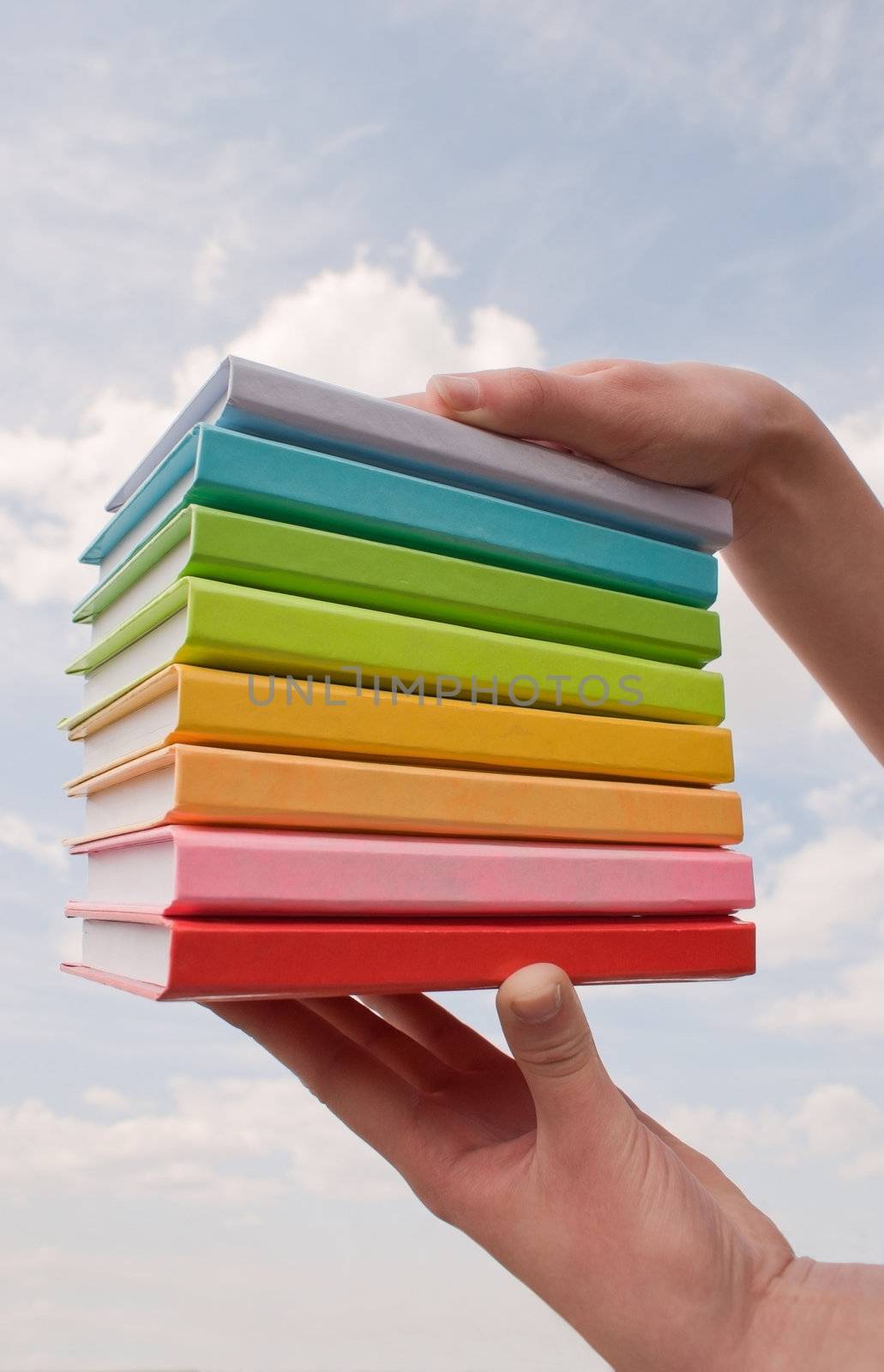 Hands holding color hard cover books