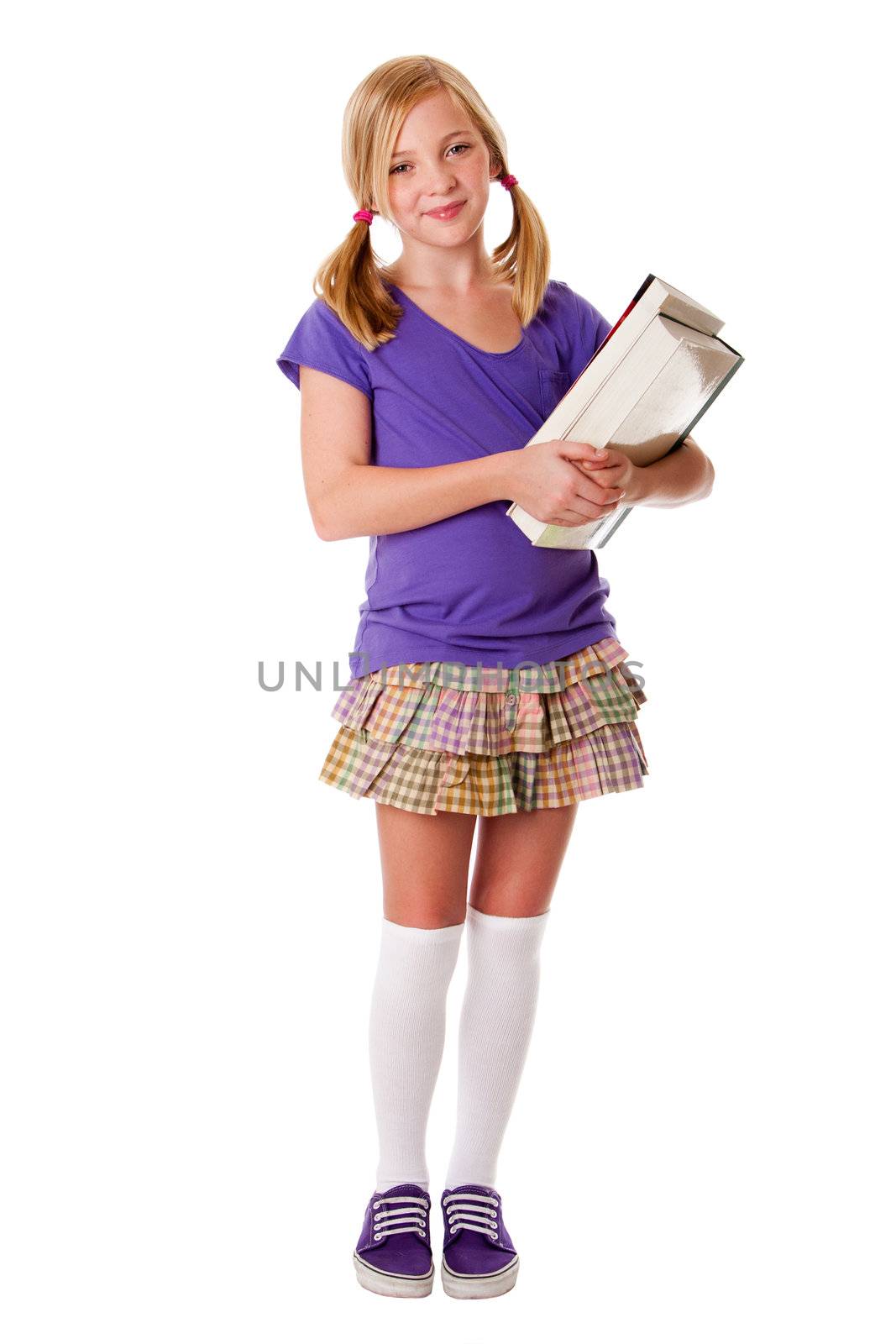 Beautiful happy teenager school girl carrying books, standing and smiling, isolated.