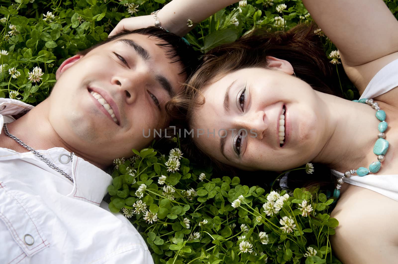 couple lays together on a grass by adam121