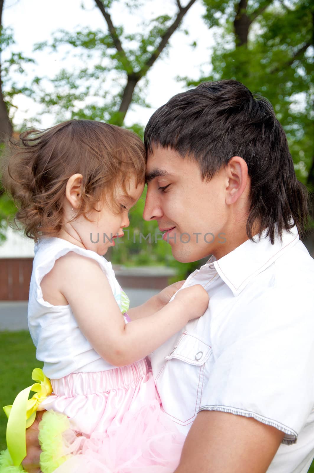 The father and the daughter together lay on a grass