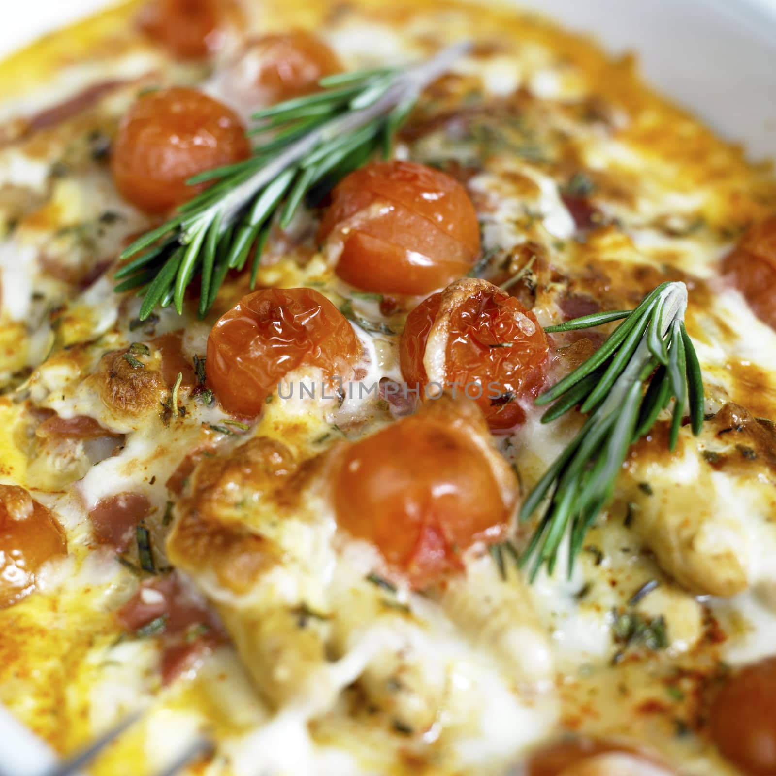 baked white asparagus with cherry tomatoes on rosemary