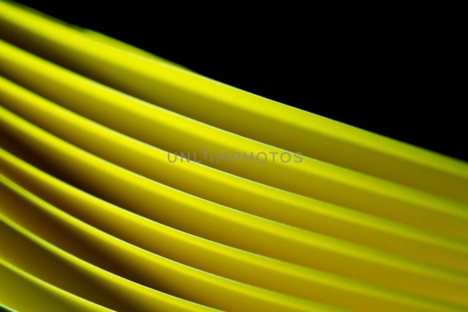 blurred edges of yellow A$ paper illuminated with LED lights on black background