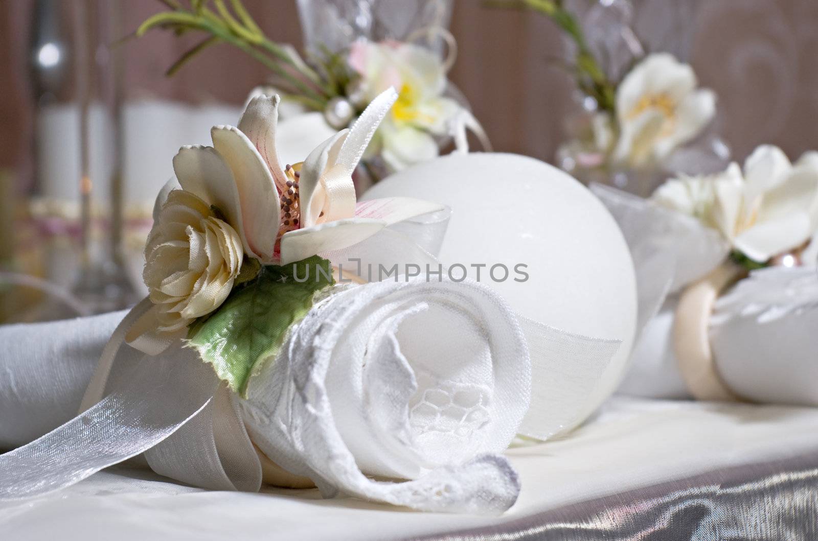 Twisted napkin decorated with flowers lies on the holiday table