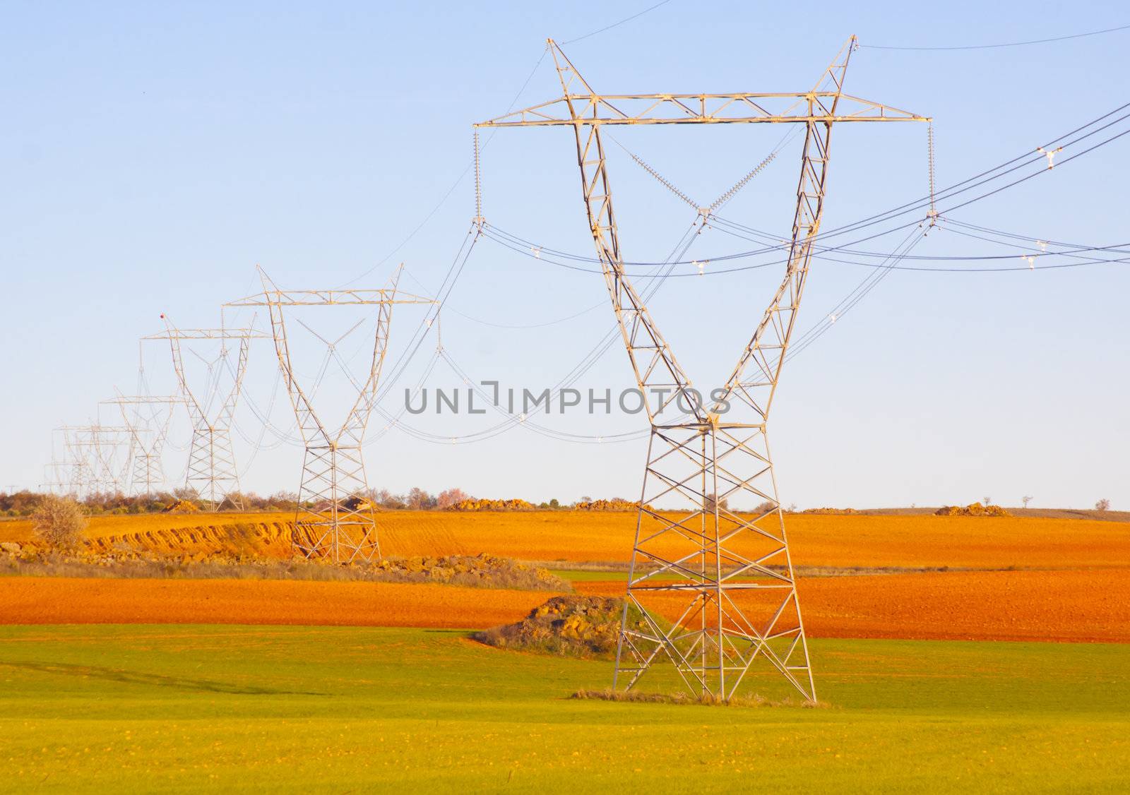 High tension 
transmission lines crossing the colorful fields of Spain.